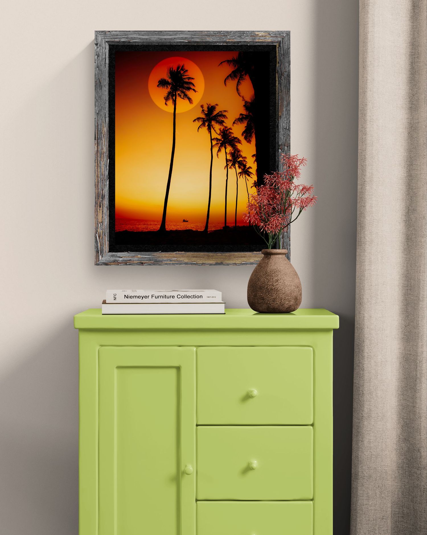Framed tropical sunset print with palm trees above a lime green cabinet with vase and books.