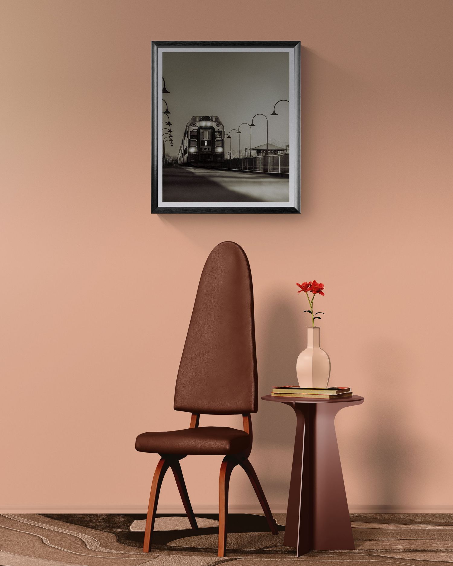 Brown leather chair beside a small round table with a red flower vase, beneath a framed black and white train photograph.