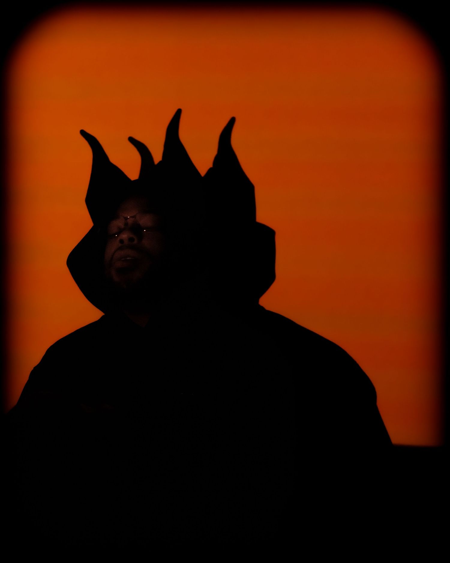 Dramatic orange sunset silhouette with jagged edges against dark background.