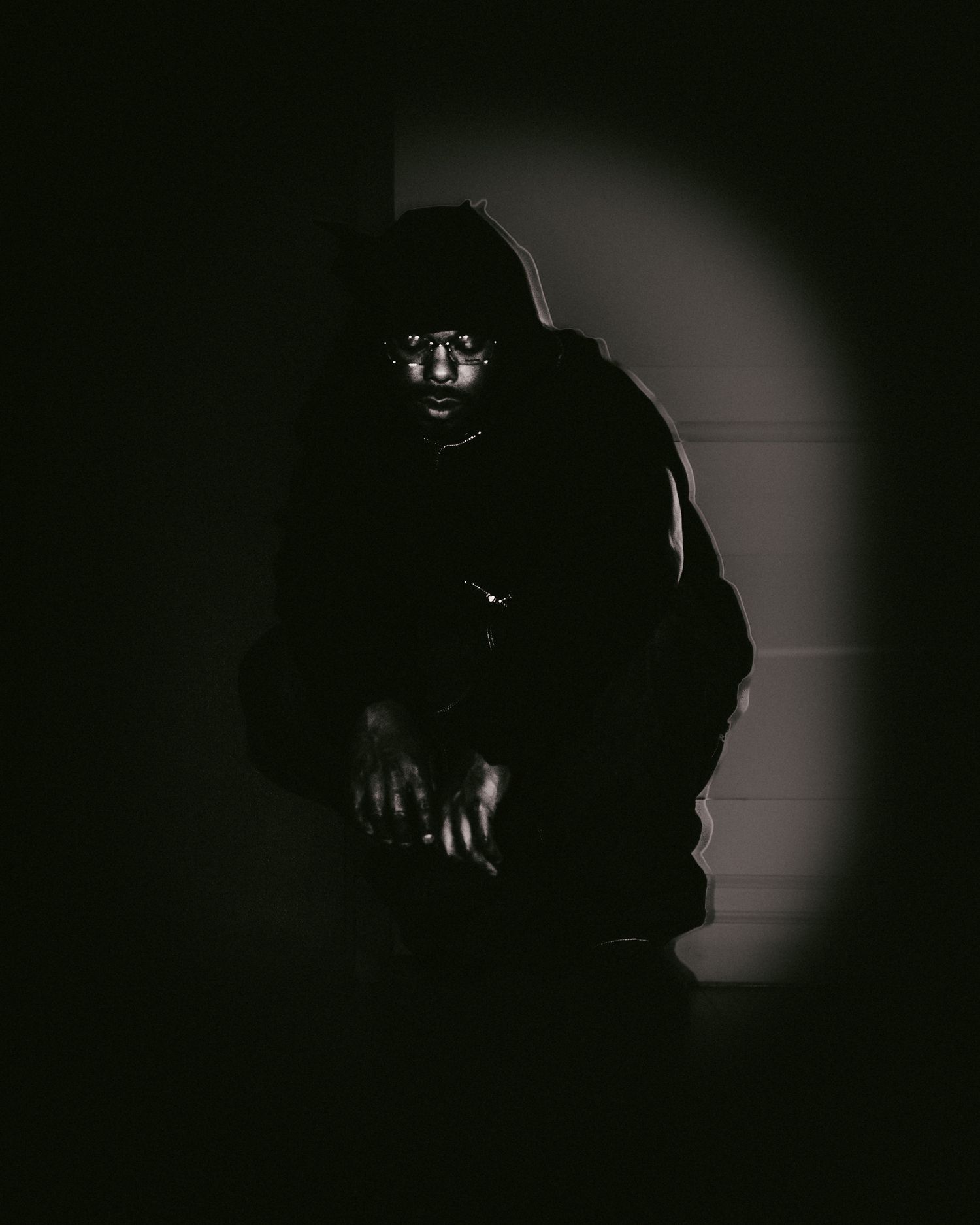 Shadowy figures in dark room with dramatic spotlight effects.