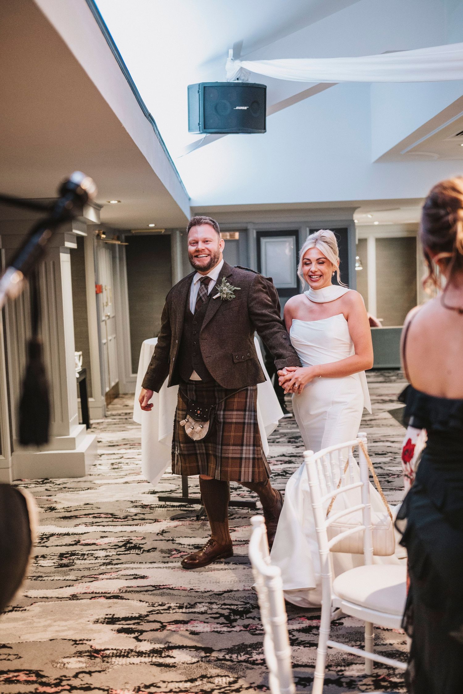 A sequence of wedding party photos showing people playing musical chairs at a reception in a carpeted banquet room.
