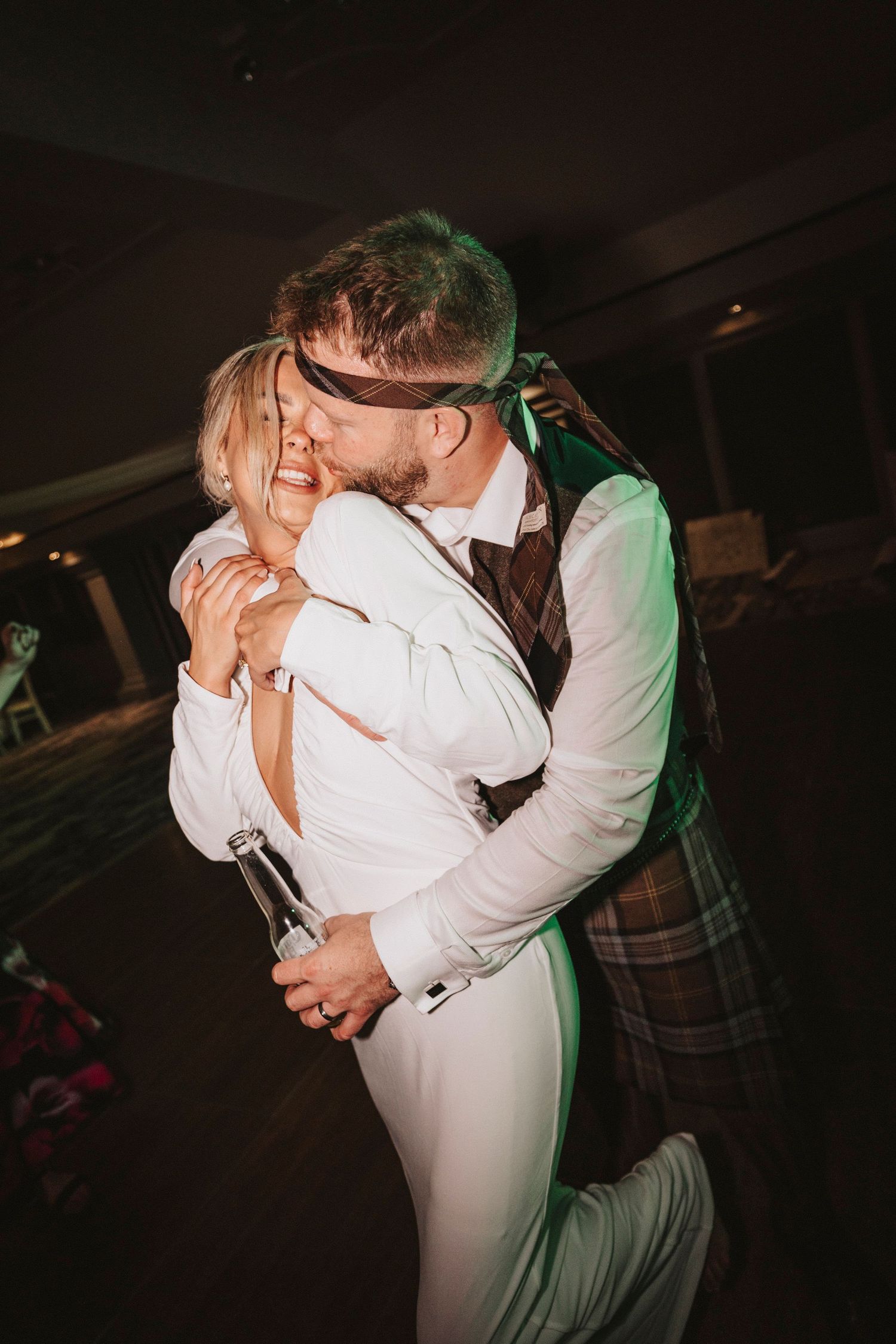 Romantic dance sequence shows couple in white attire embracing and sharing intimate moments on darkened dance floor.