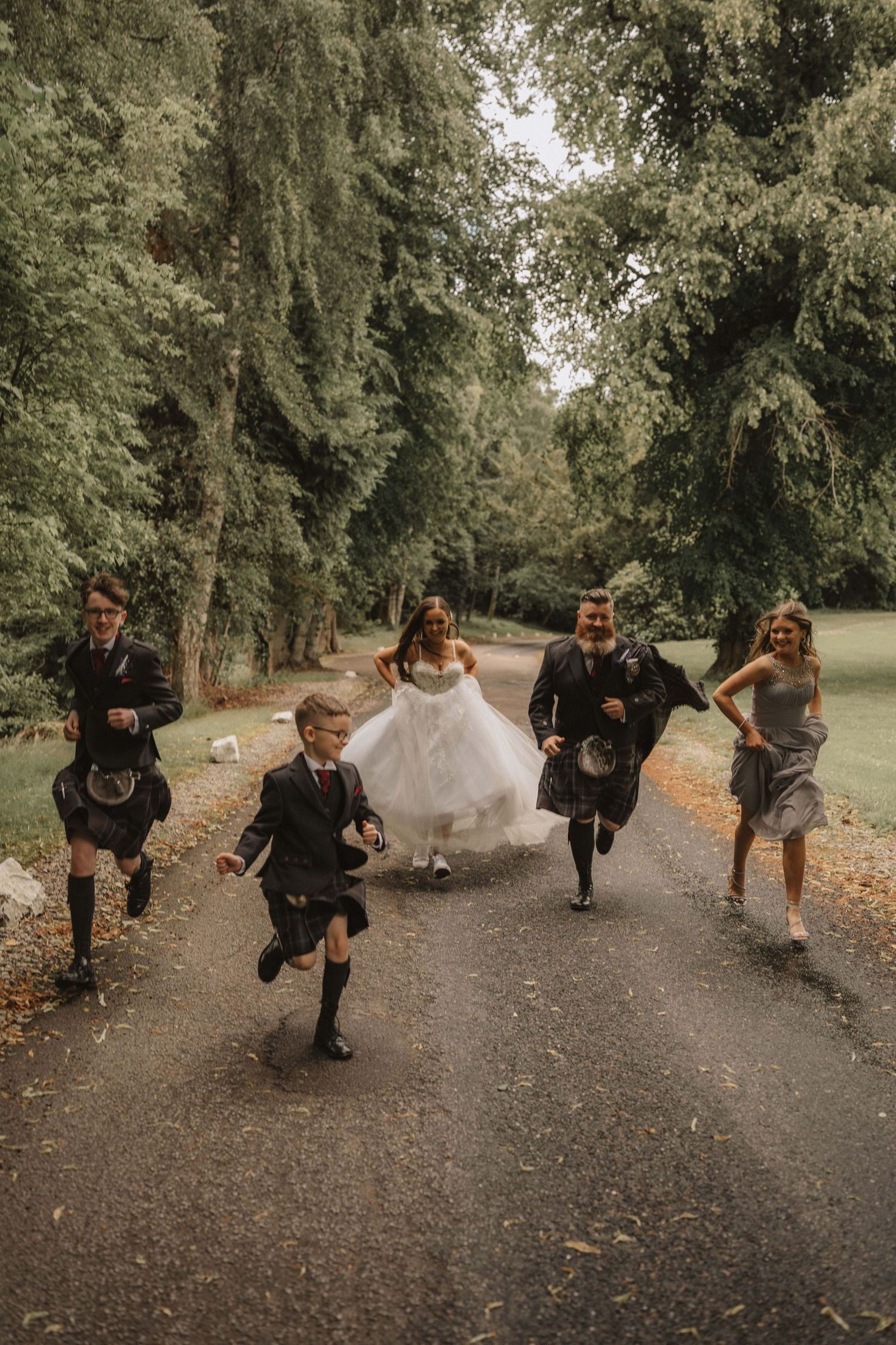 Wedding party running playfully down a tree-lined path in an energetic photo sequence.