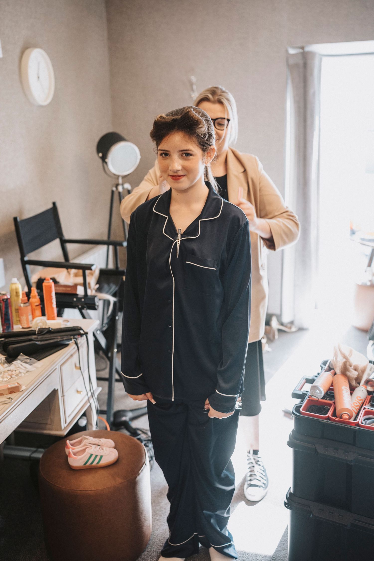 Getting ready scene with someone wearing black silk pajamas during wedding preparations.