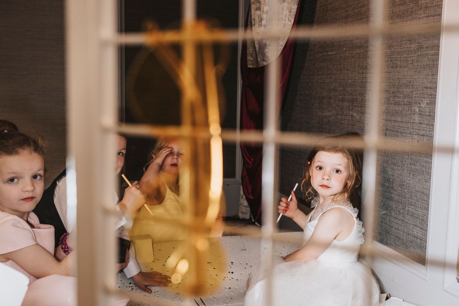 A child looks intently at a glowing candle in a cozy indoor setting during a special moment.
