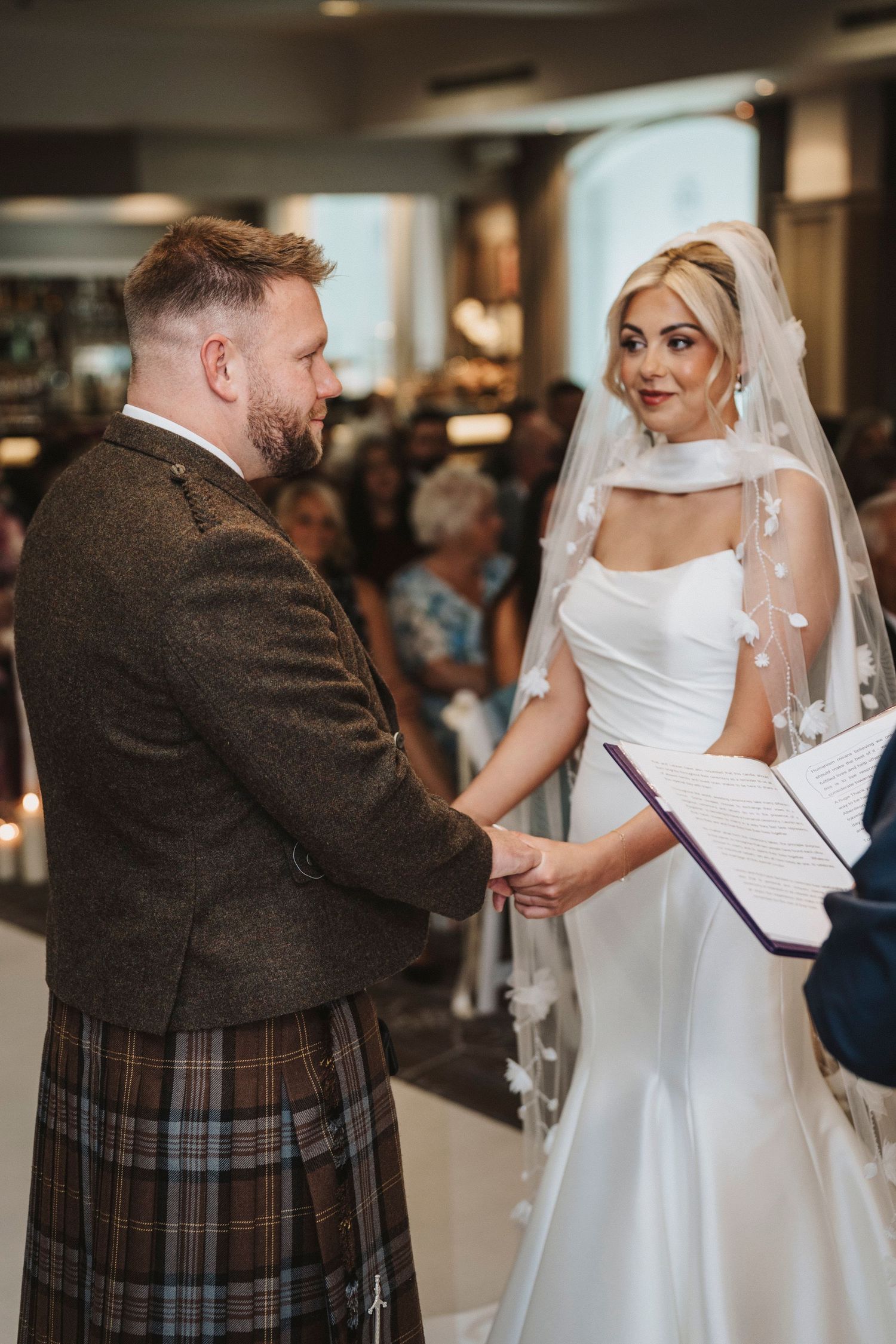 A sequence of photos showing a first dance between newlyweds at a wedding reception, with the groom in a kilt.