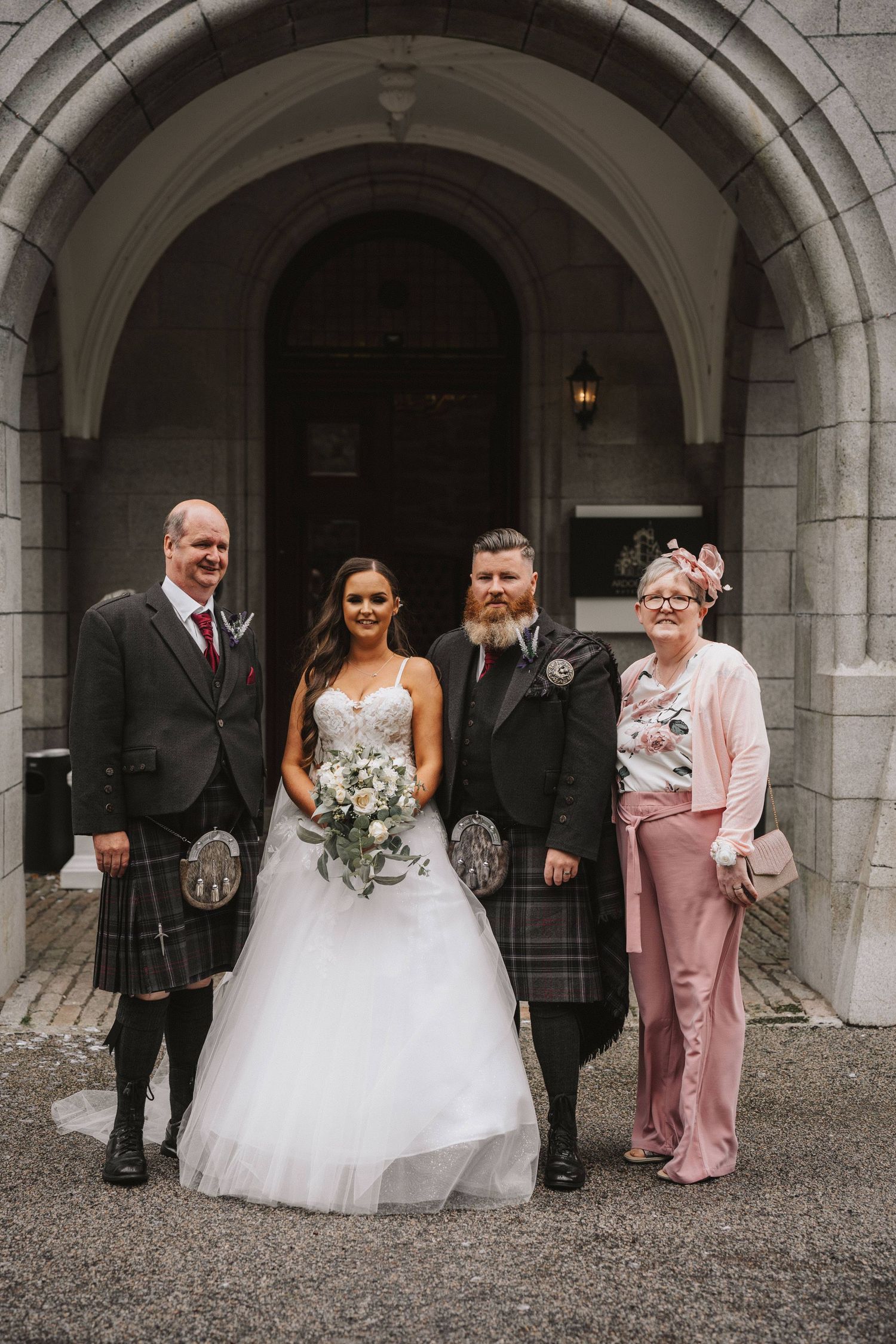 Wedding party in formal attire poses under stone archways in a series of candid outdoor photographs.