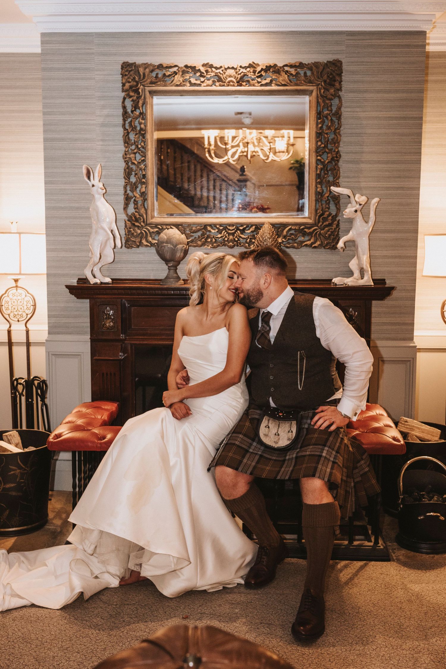 A romantic wedding photo series showing intimate moments between a couple in formal attire by an elegant fireplace.