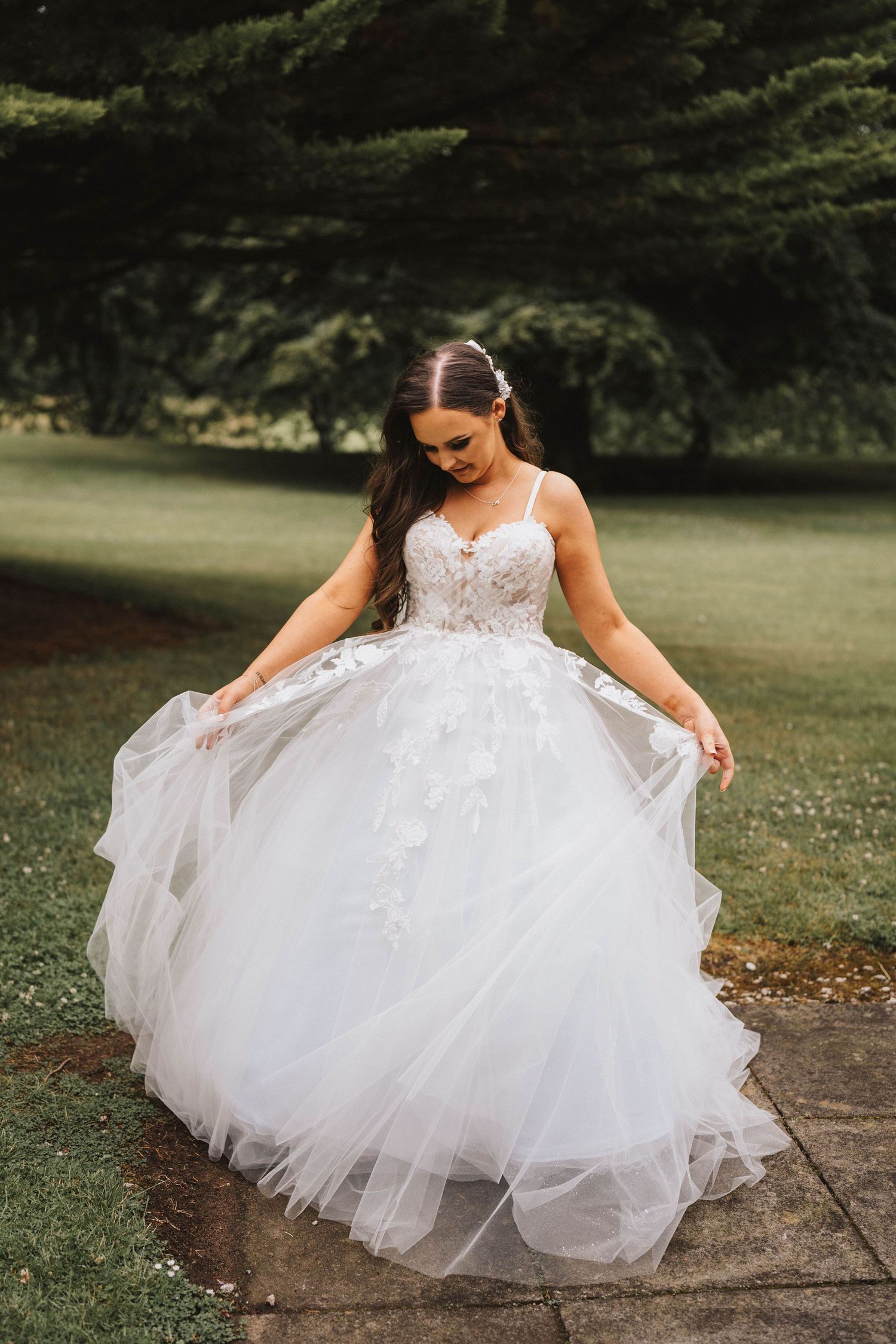Close-up view of a voluminous white wedding dress with intricate lace details and tulle skirt.