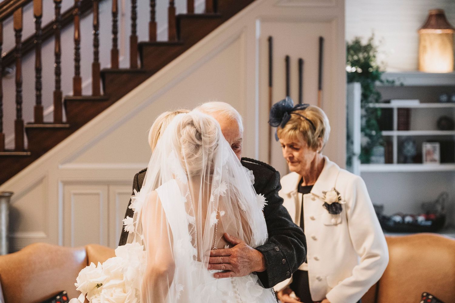A couple shares an intimate moment during their first dance at an elegant indoor wedding reception.