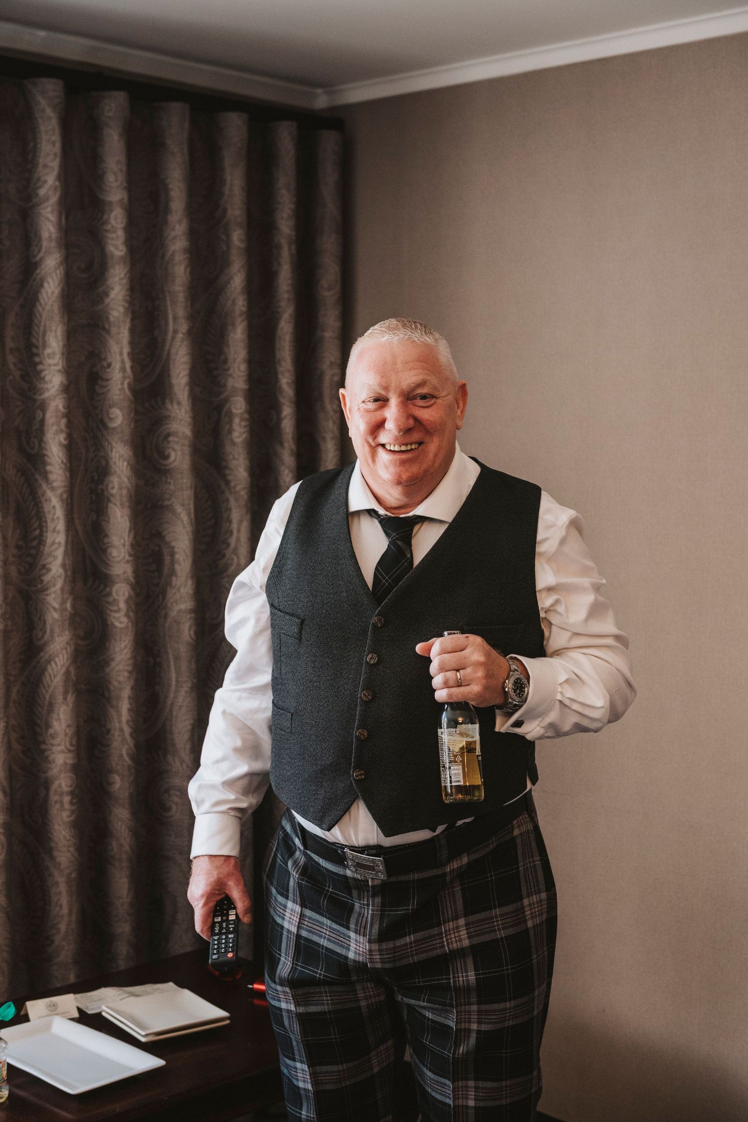 A sequence of four photos showing someone in traditional Scottish attire with a black vest and plaid kilt holding a drink.
