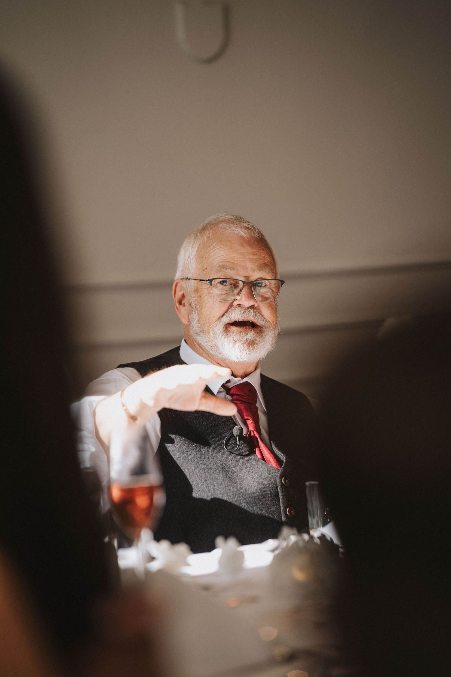 Sequence of candid reception photos showing a guest laughing heartily at a wedding dinner table.