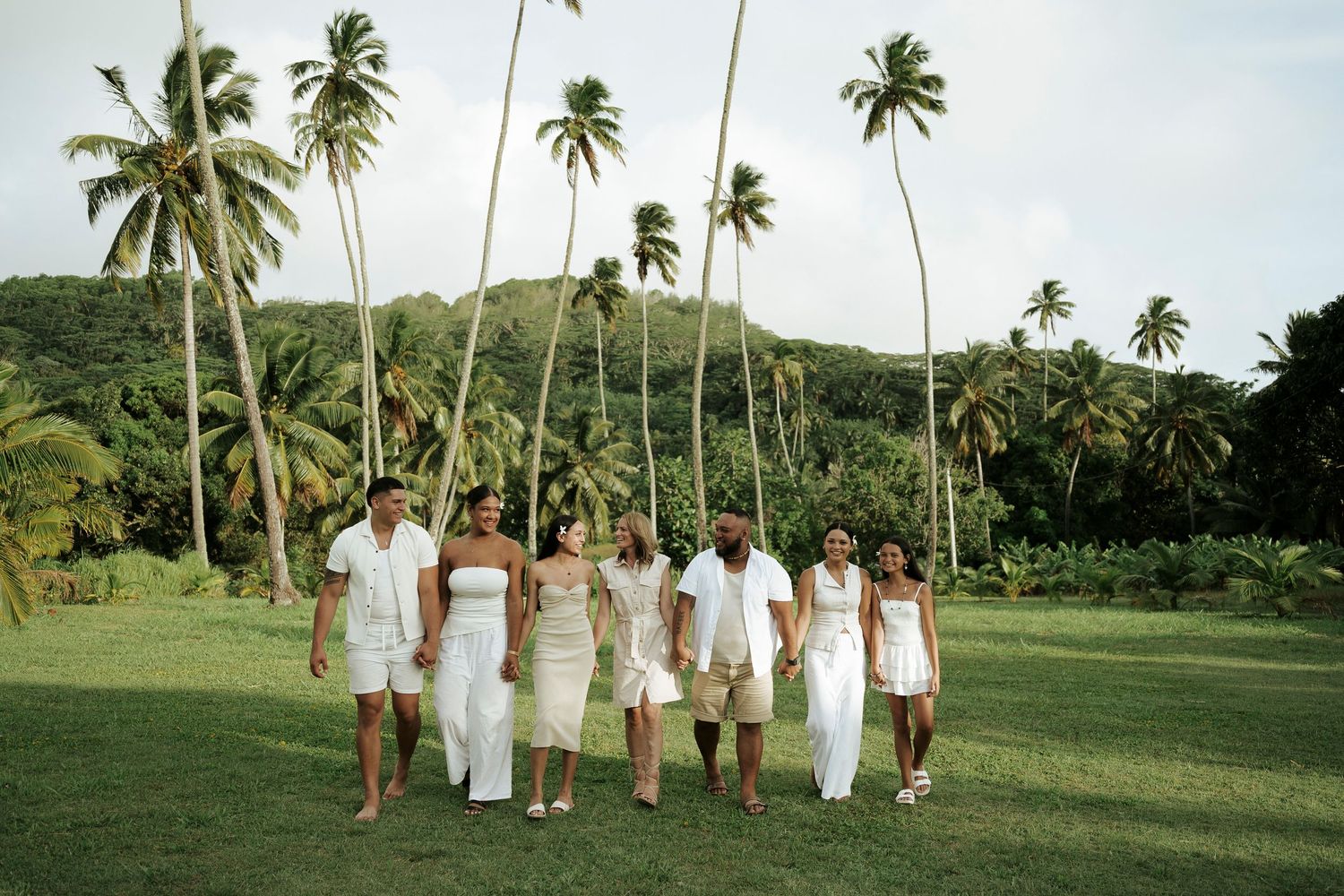 Young family smiling together under coconut palms – relaxed island family photo session