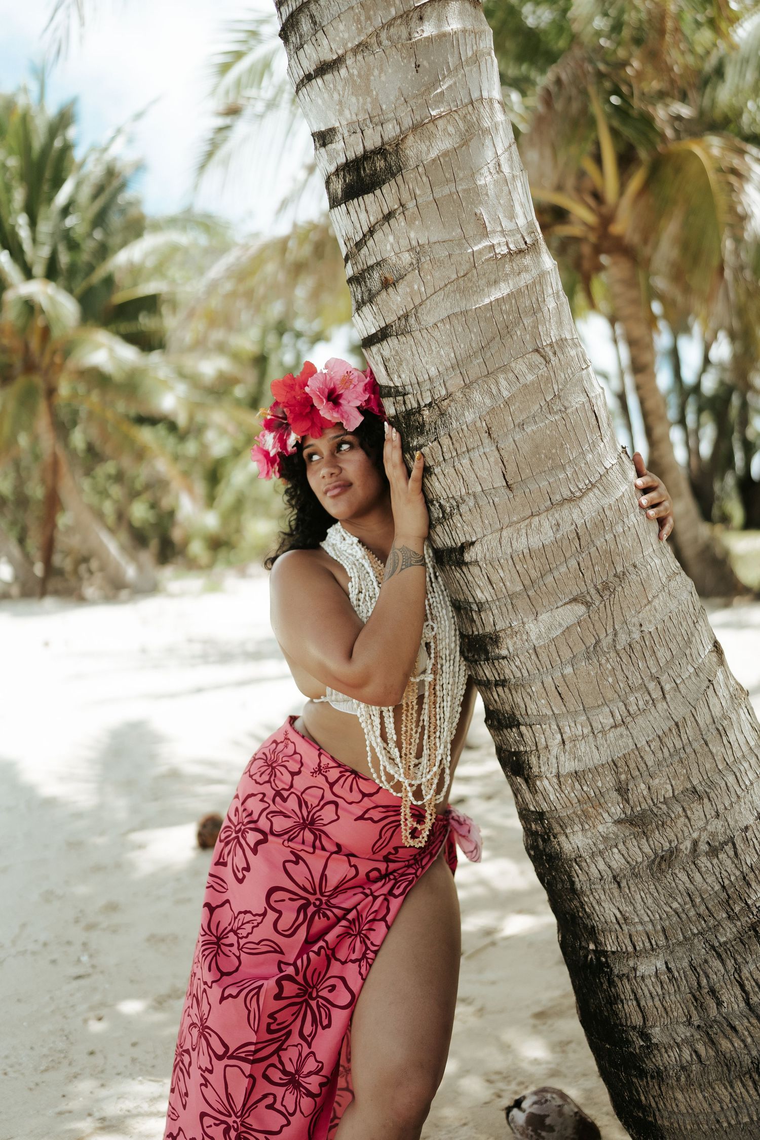 Woman in pink pareu smiling under coconut tree – Rarotonga island portrait