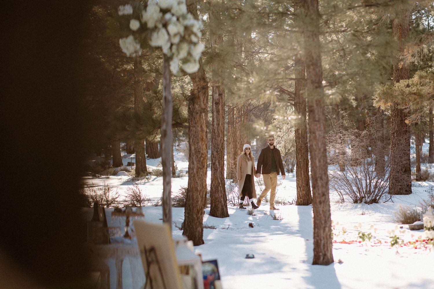 Snow-covered forest path decorated for winter wedding ceremony.