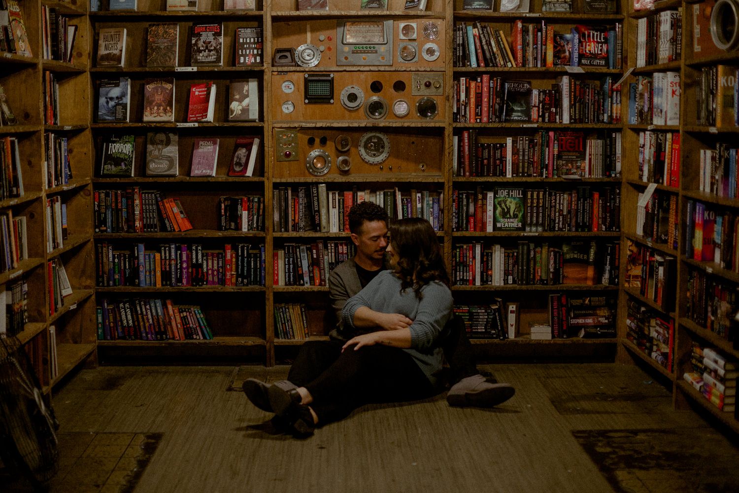Intimate moment in a bookstore with shelves of books creating warm ambiance.