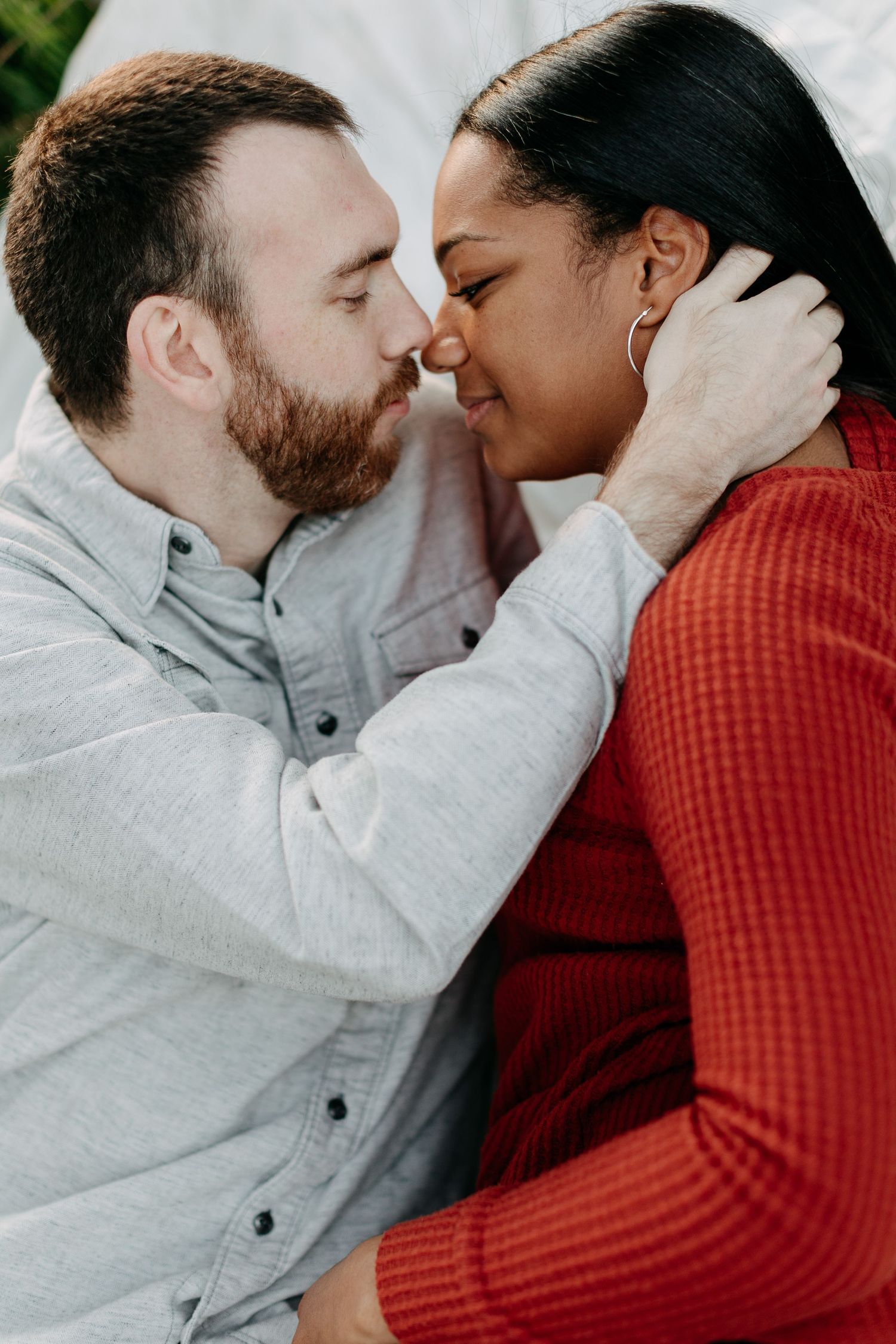 Close-up portrait of couple in red and gray sharing intimate moment.
