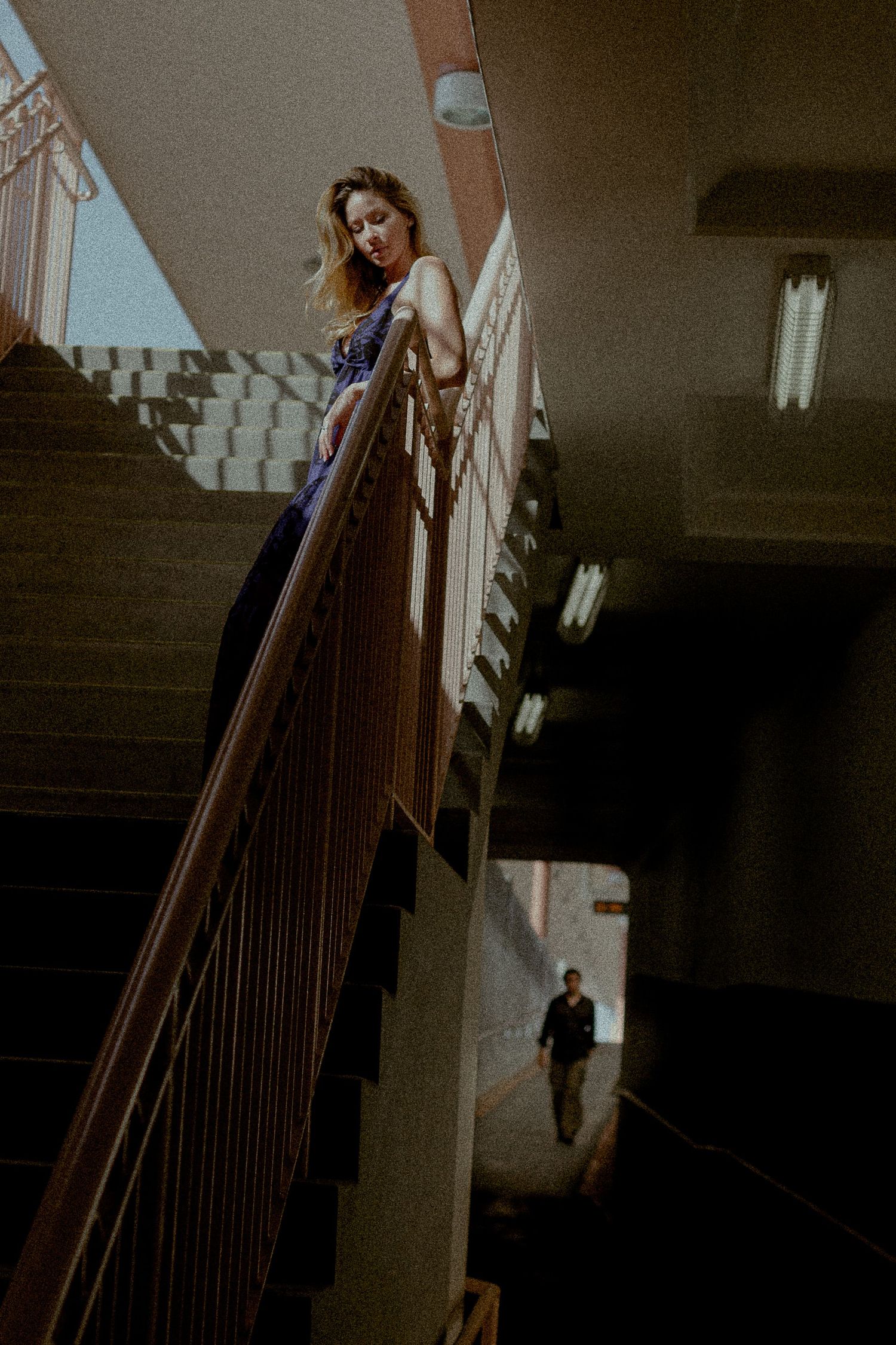Atmospheric stairwell scene showing contrasting light and shadows with dramatic composition.