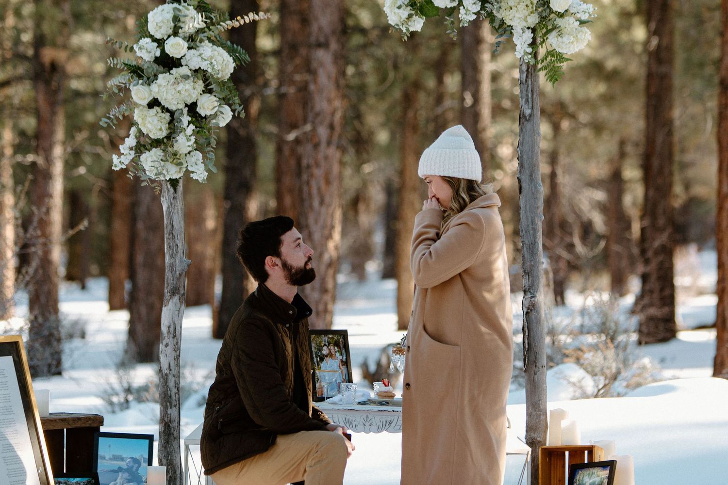 A proposal scene in winter forest with decorative white flowers and scattered red roses.