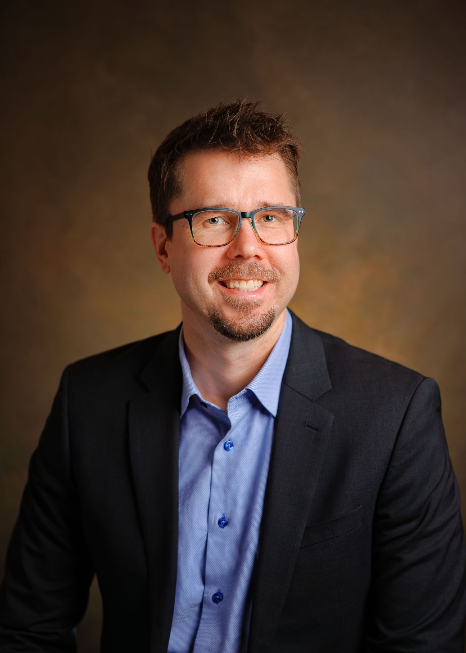 Professional studio portrait series showing a person in glasses and business attire against a dark brown backdrop.