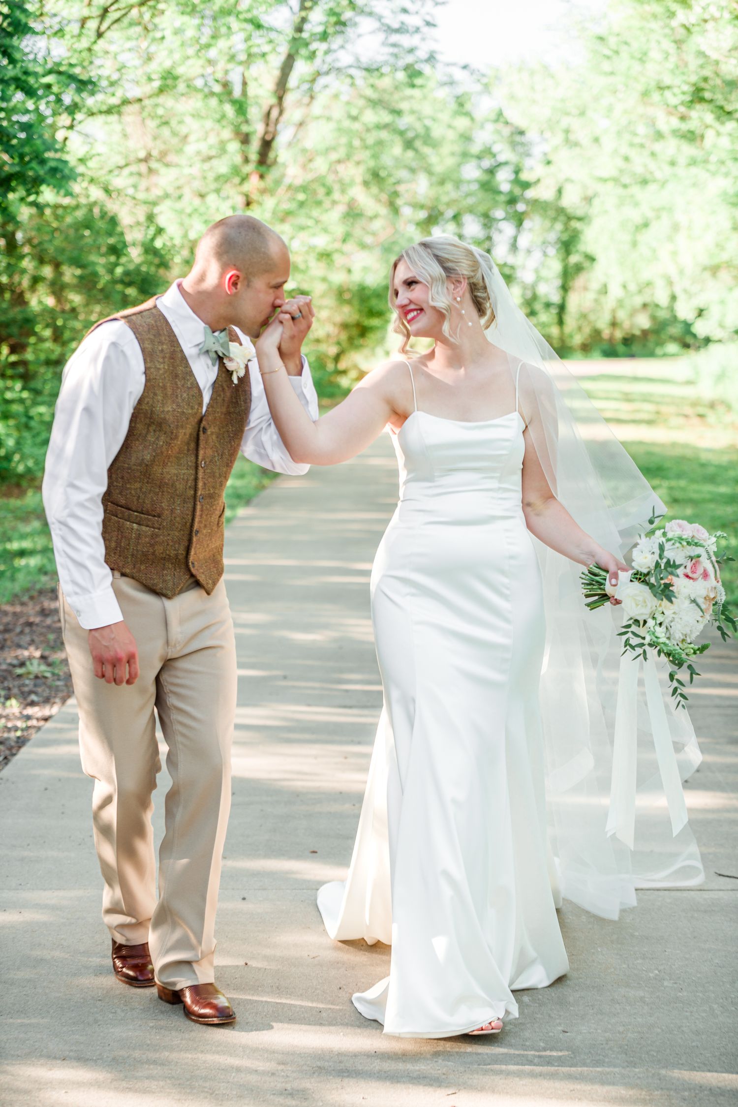 Bride and groom share tender moment on wooded path during wedding photos by Stephanie Coulter Photography