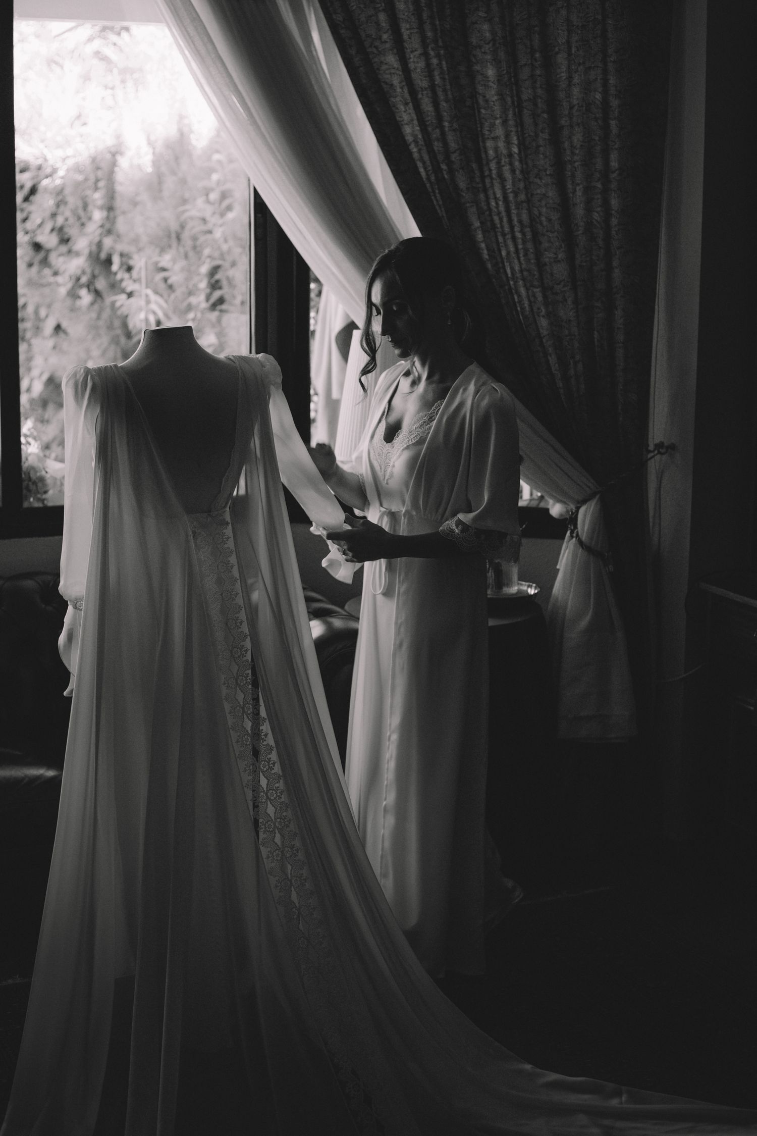 Fotografía editorial de bodas, novia admirando su vestido