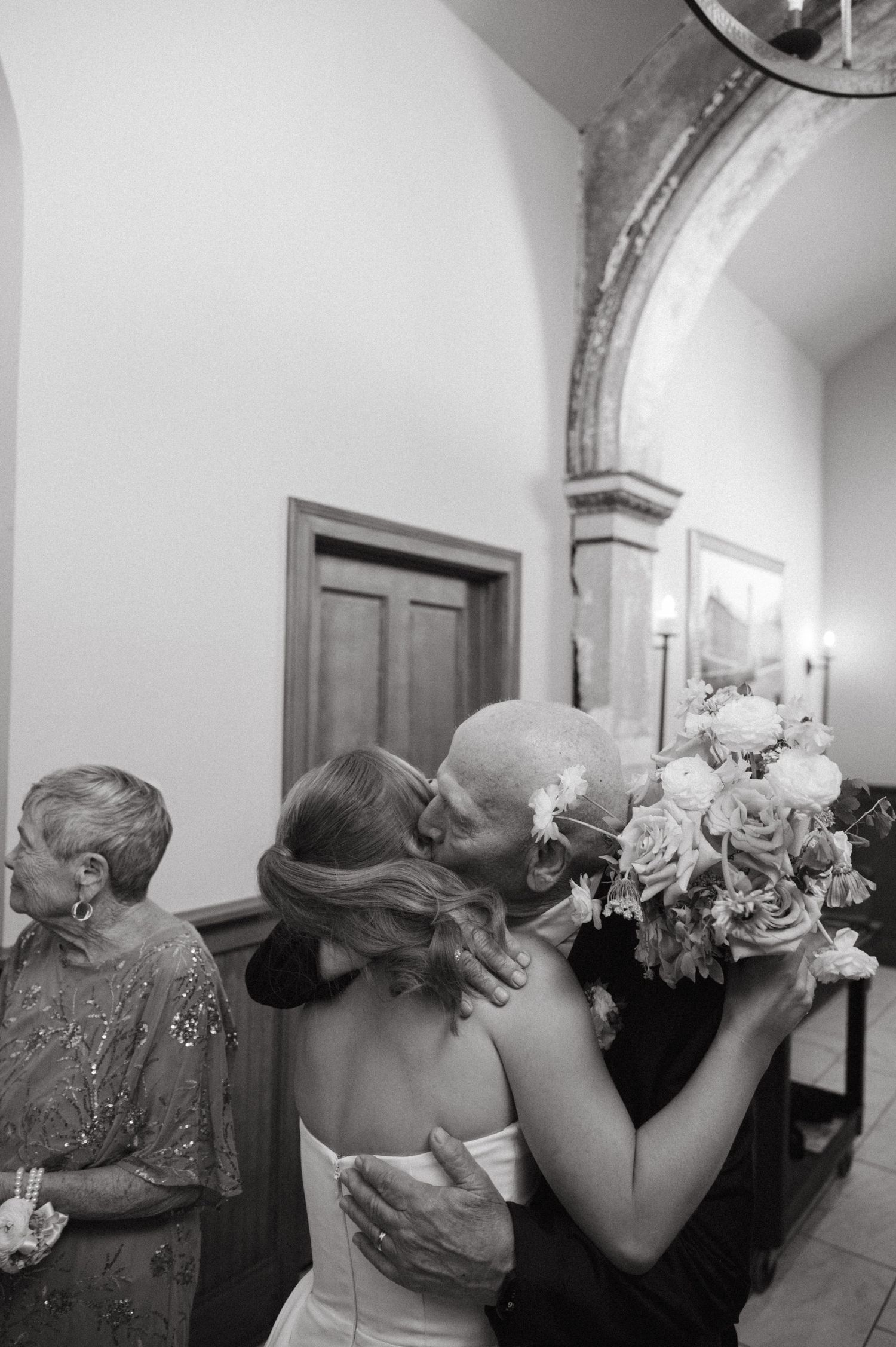 Two emotional moments captured in black and white at a formal event showing tender embraces in a hallway.