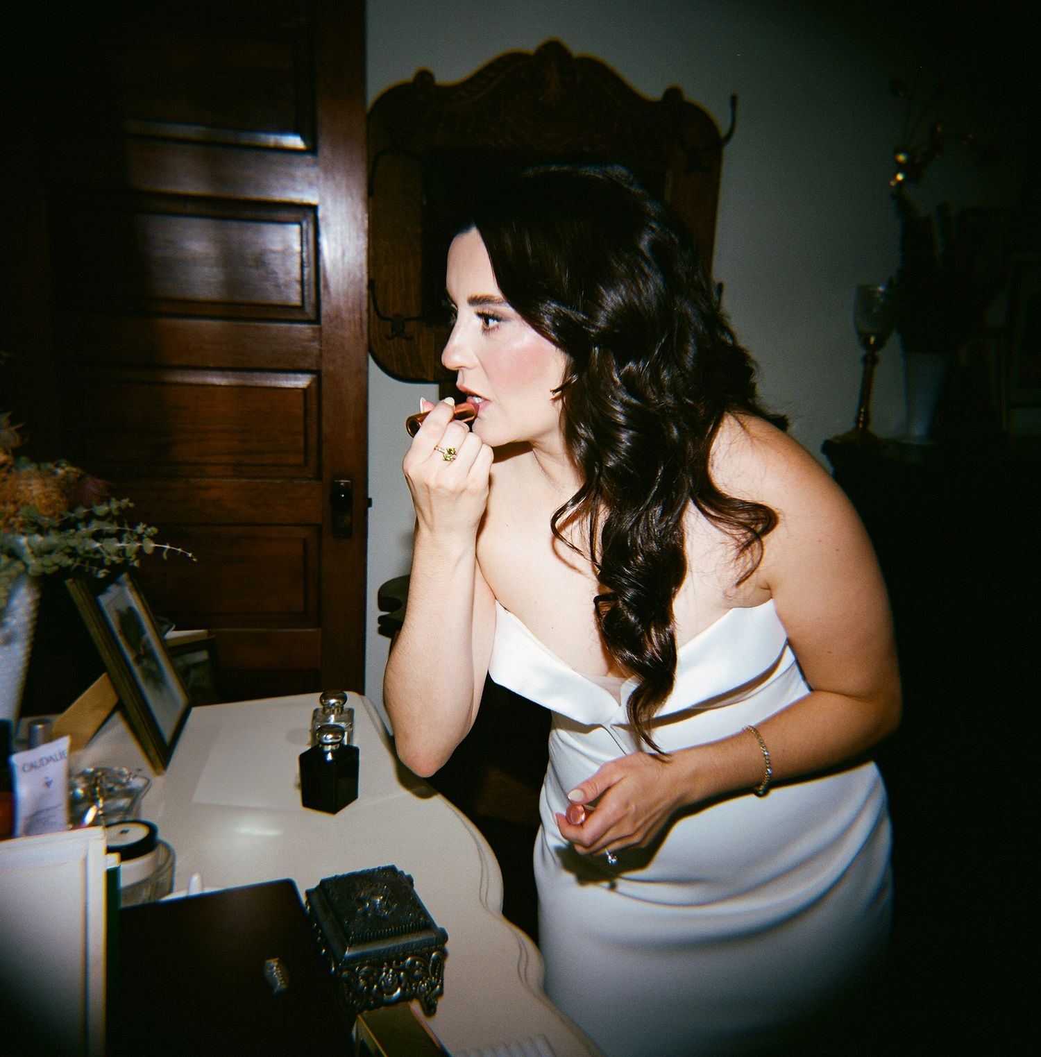 Series of dark, grainy film photos showing someone in a white dress sitting and gesturing in dim lighting.