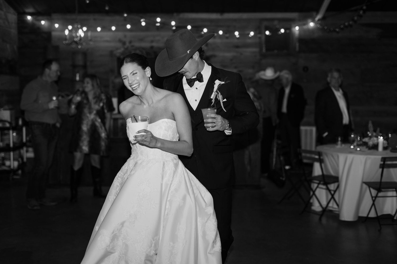 Black and white photo of bride and groom sharing a dance at their wedding reception.