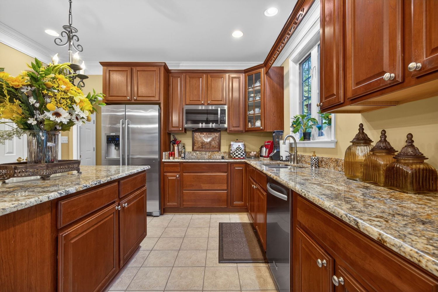 Spacious kitchen featuring rich cherry cabinets, granite counters, stainless steel appliances, and tile flooring.