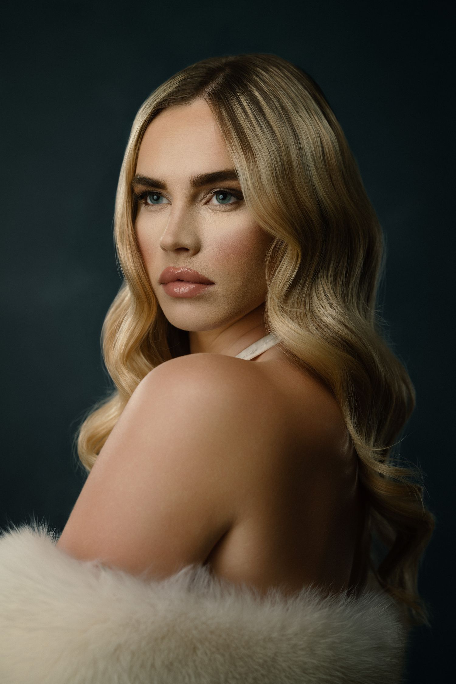Glamour beauty portrait with wavy blonde hair and fur wrap.