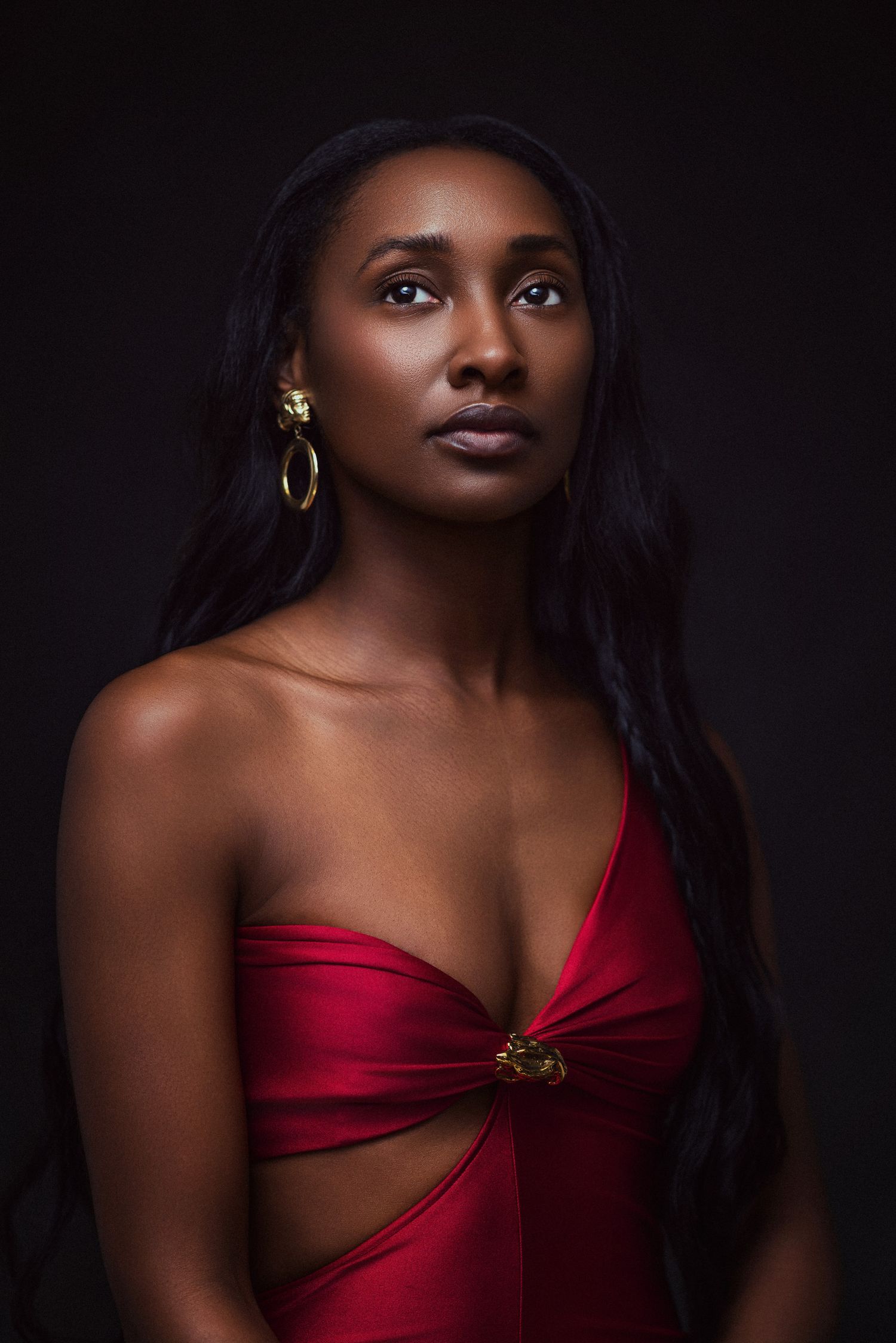 Elegant portraits featuring a red dress and gold accessories against dark dramatic background.