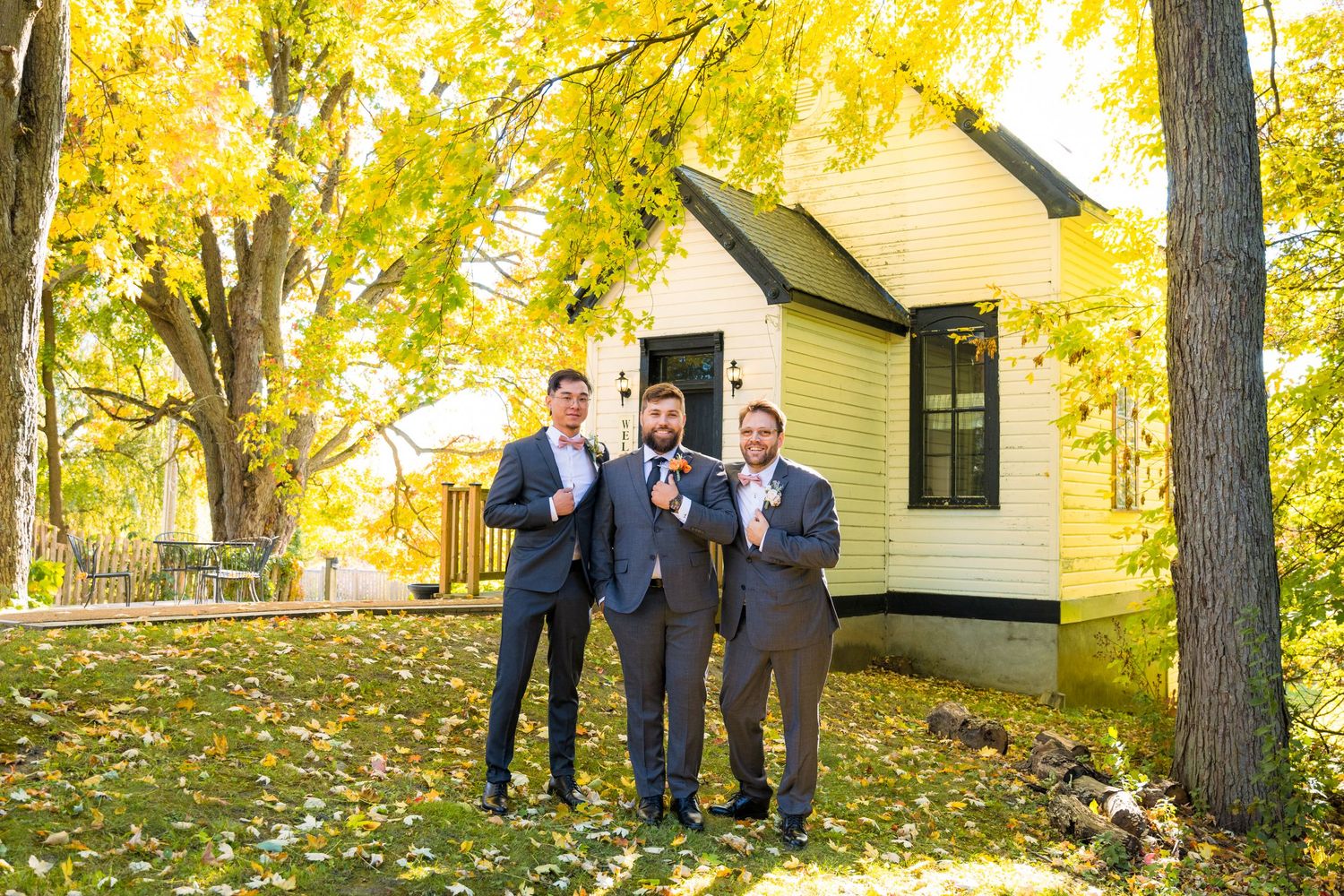 Wedding party stands together under golden autumn trees on a sunny afternoon in a park setting at Strathmere Ottawa Wedding Photographer