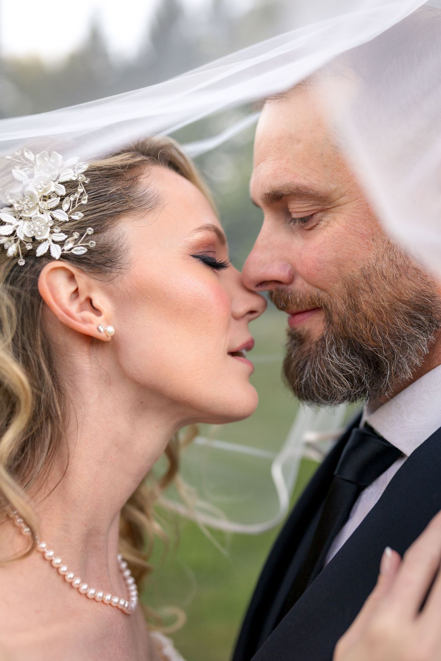 A romantic wedding portrait showing intimate close-up moments between a bride and groom with under a veil. Ottawa Wedding Photographer