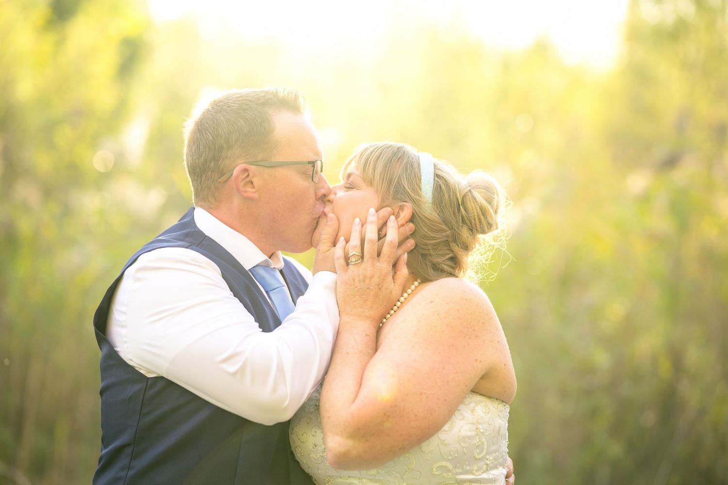 A sweet wedding moment captured in a series of photos showing a couple embracing in natural sunlit grove. Ottawa Wedding Photography