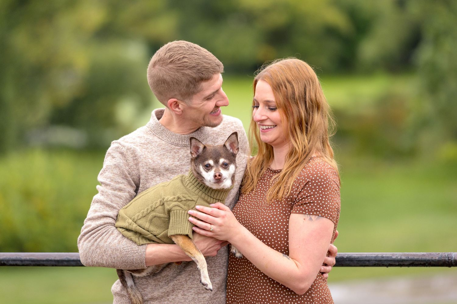 A couple poses with their grey dog in a lush garden setting. Ottawa Wedding Photographer