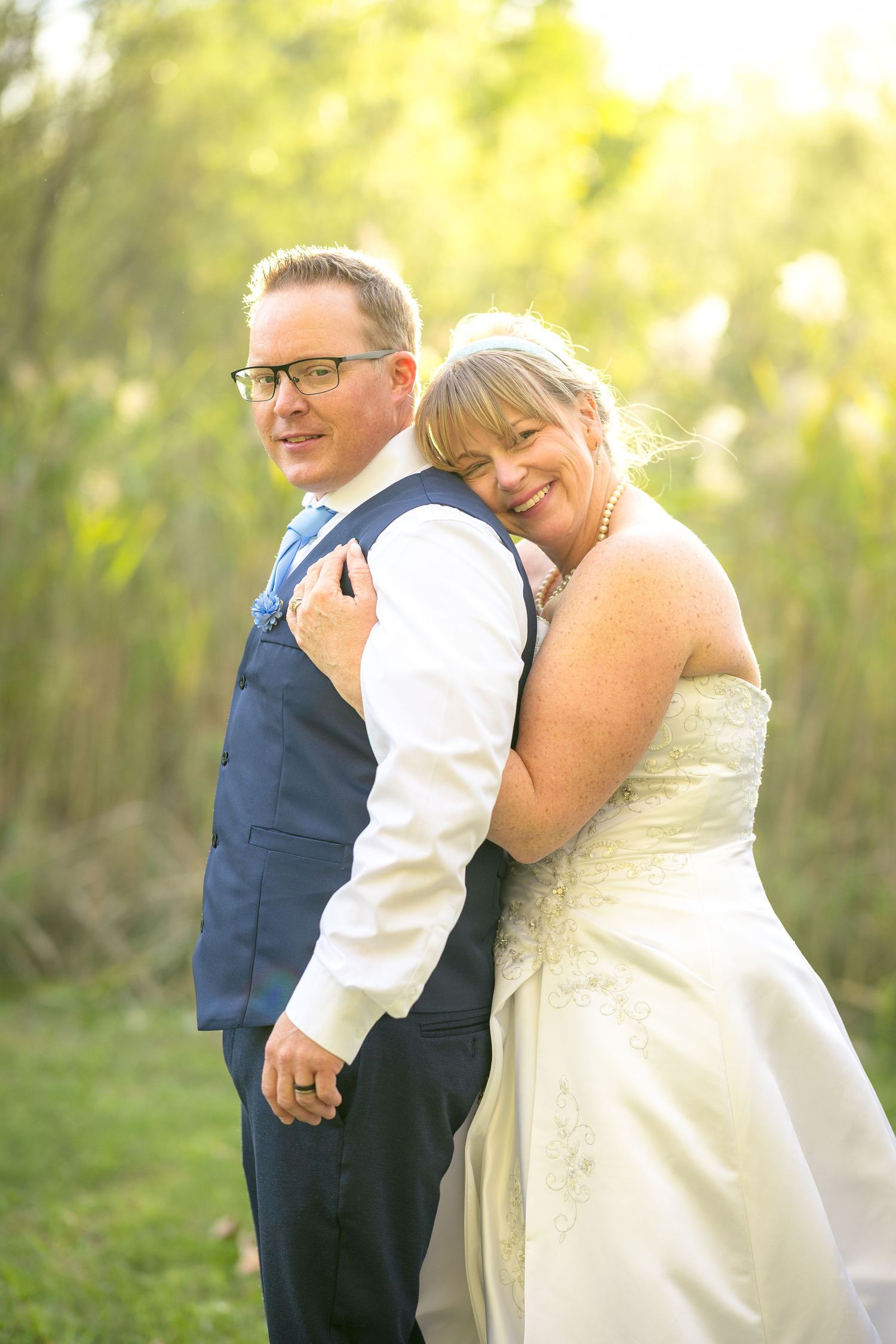 A sweet wedding moment captured in a series of photos showing a couple embracing in natural sunlit grove. Ottawa Wedding Photography
