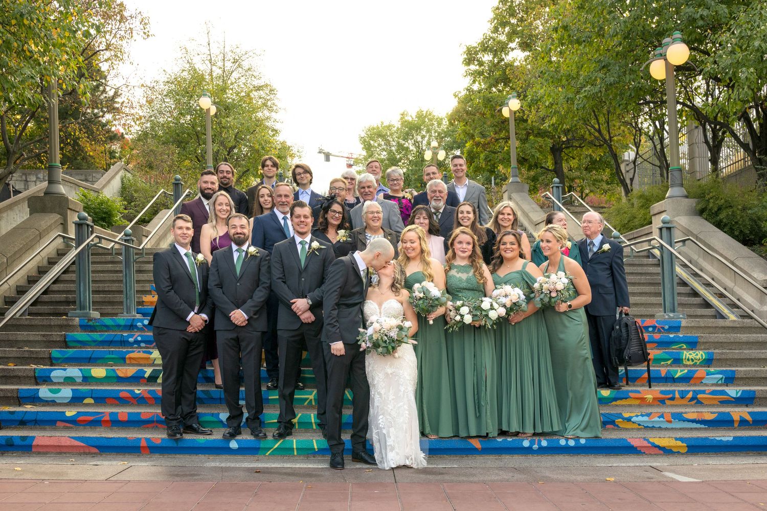 Wedding party poses together on colorful painted steps in Ottawa setting during a wedding. Ottawa wedding photographer near me
