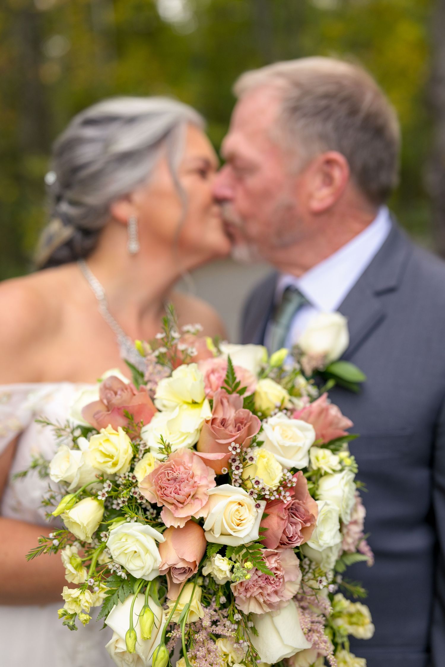A romantic wedding, the bride & groom share an intimate moment behind the wedding bouquet. Ottawa wedding photographer