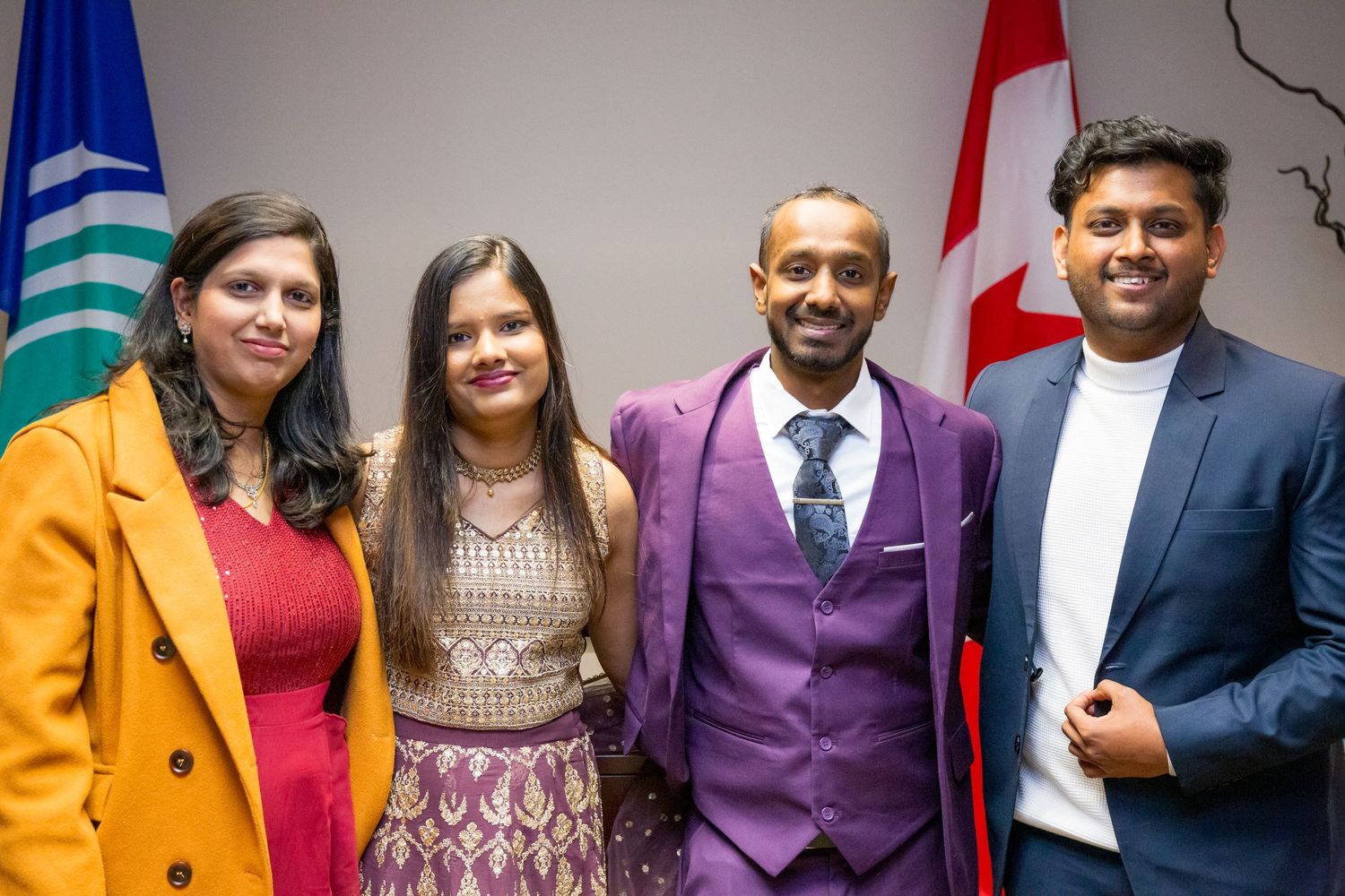A group poses together wearing colorful formal attire including purple, orange, and red.