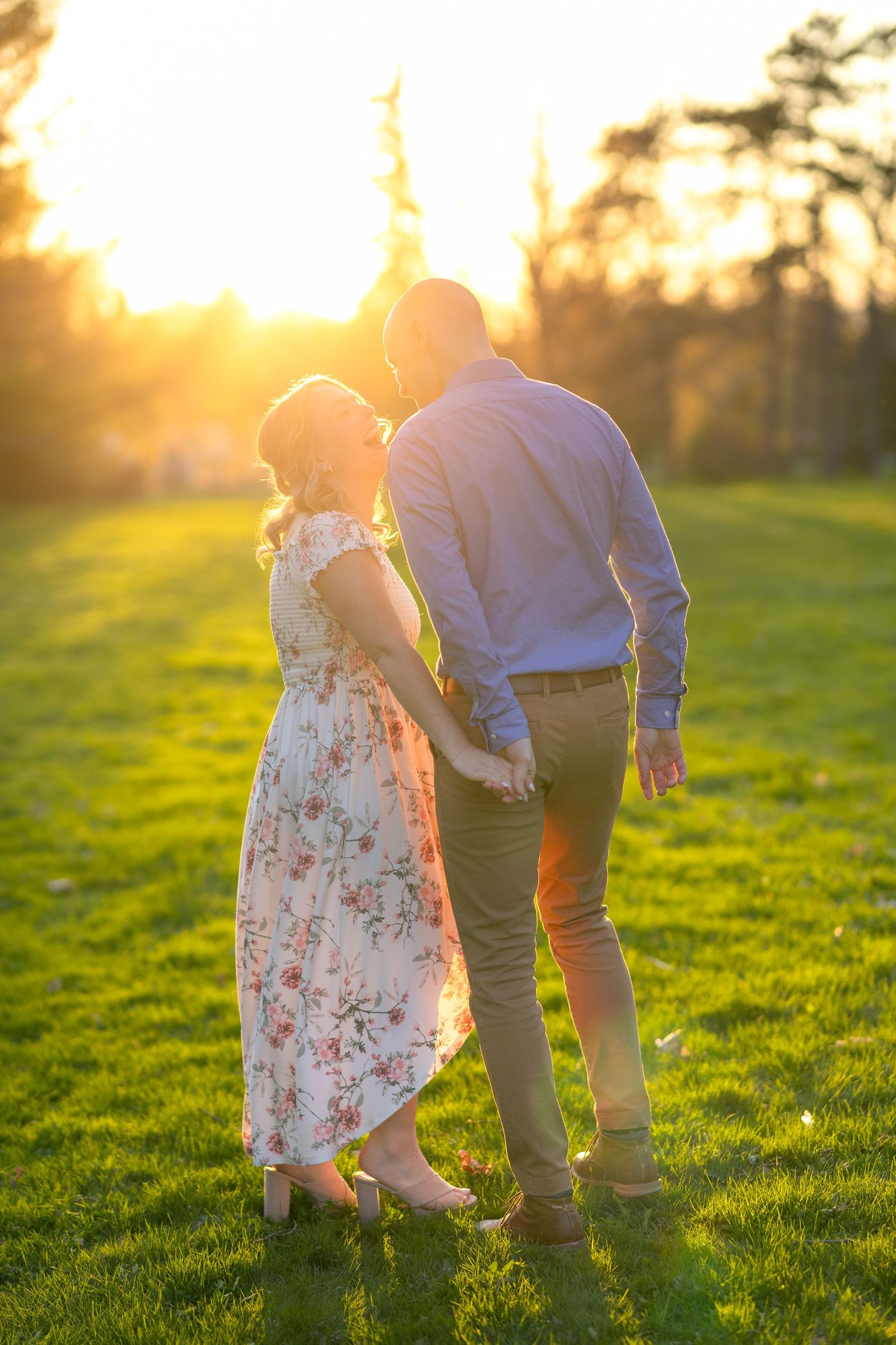 A couple stands together in a grassy field during golden hour sunset. Ottawa Wedding Photographer