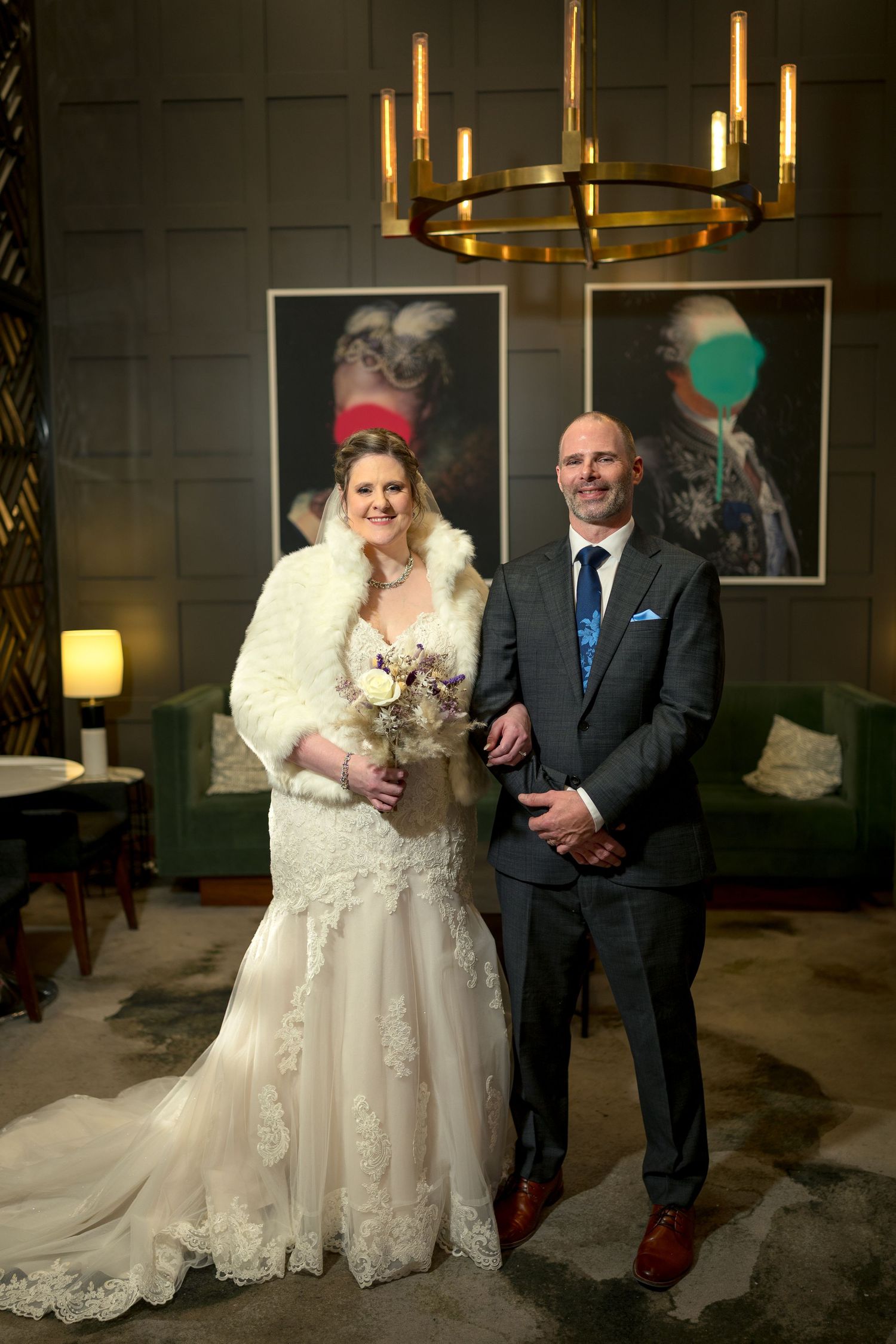 A bride & groom pose together at their winter wedding, with the bride in a lace gown and the groom in a suit. Ottawa Wedding Photography
