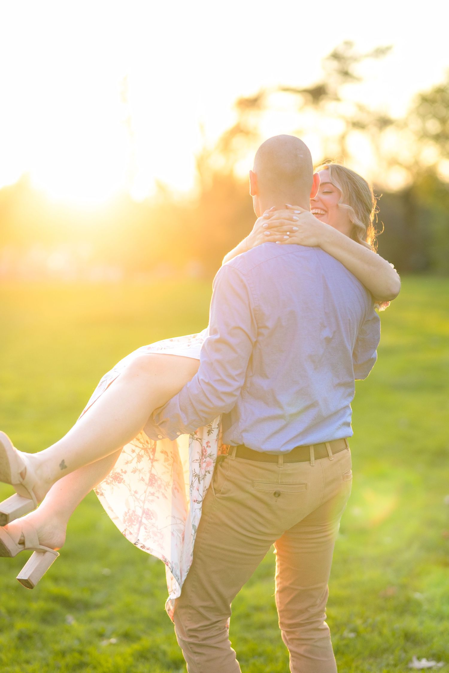 A romantic lift pose backlit by golden sunset light in a spring field. Ottawa Wedding Photographer