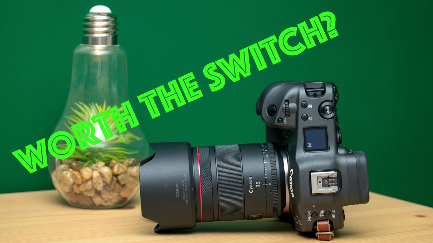 Canon R3 camera and 35mm 1.4 VCM L Lens beside a light bulb on a wooden surface with green background and text reading Worth The Switch?