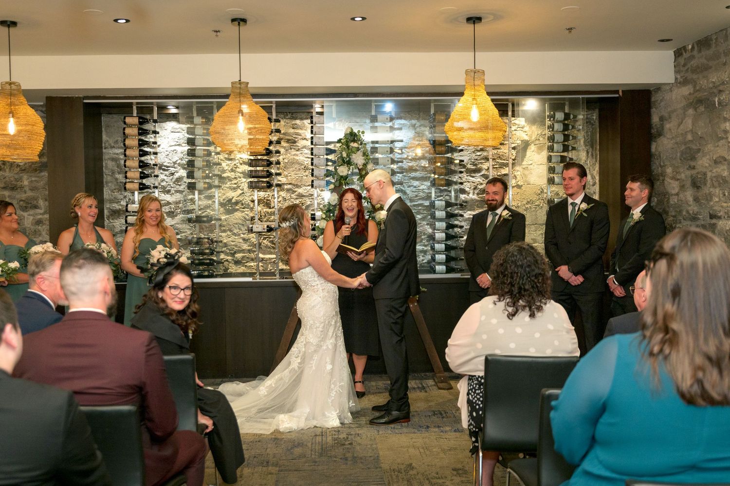 Wedding ceremony participants share an emotional moment during ring exchange at the Sidedoor restaurant Ottawa wedding photographer
