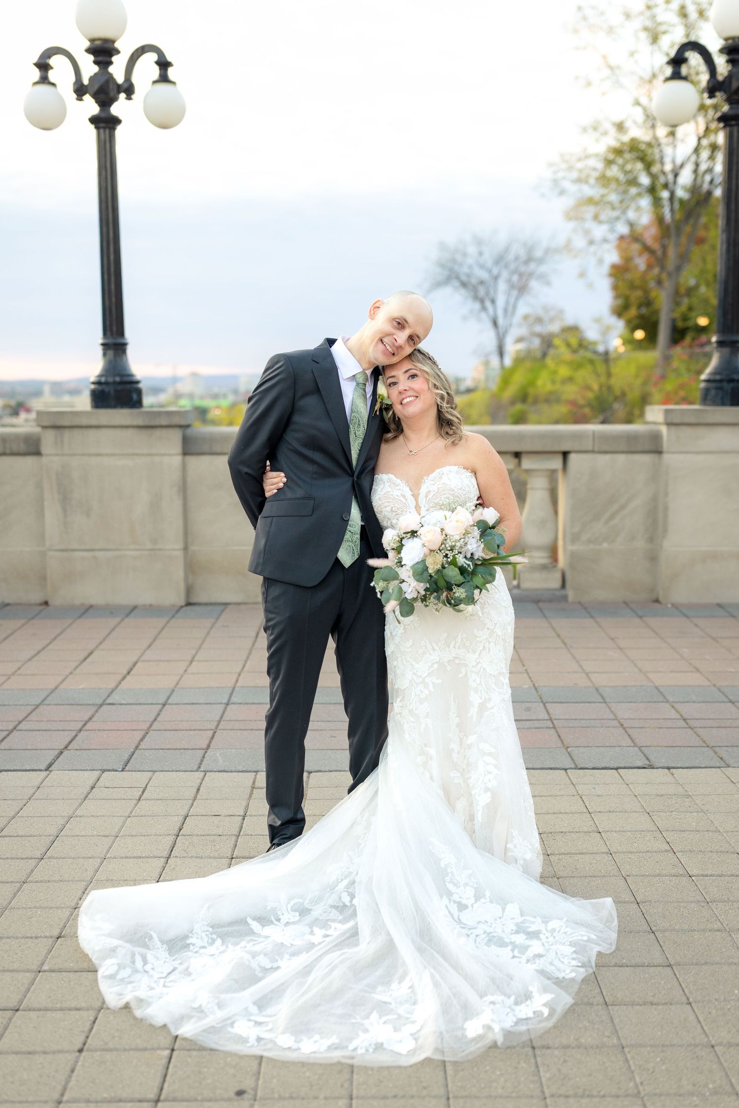 A romantic wedding couple on an elegant stone terrace with ornate lamp posts at the Fairmont Château Laurier. Ottawa Wedding photographer