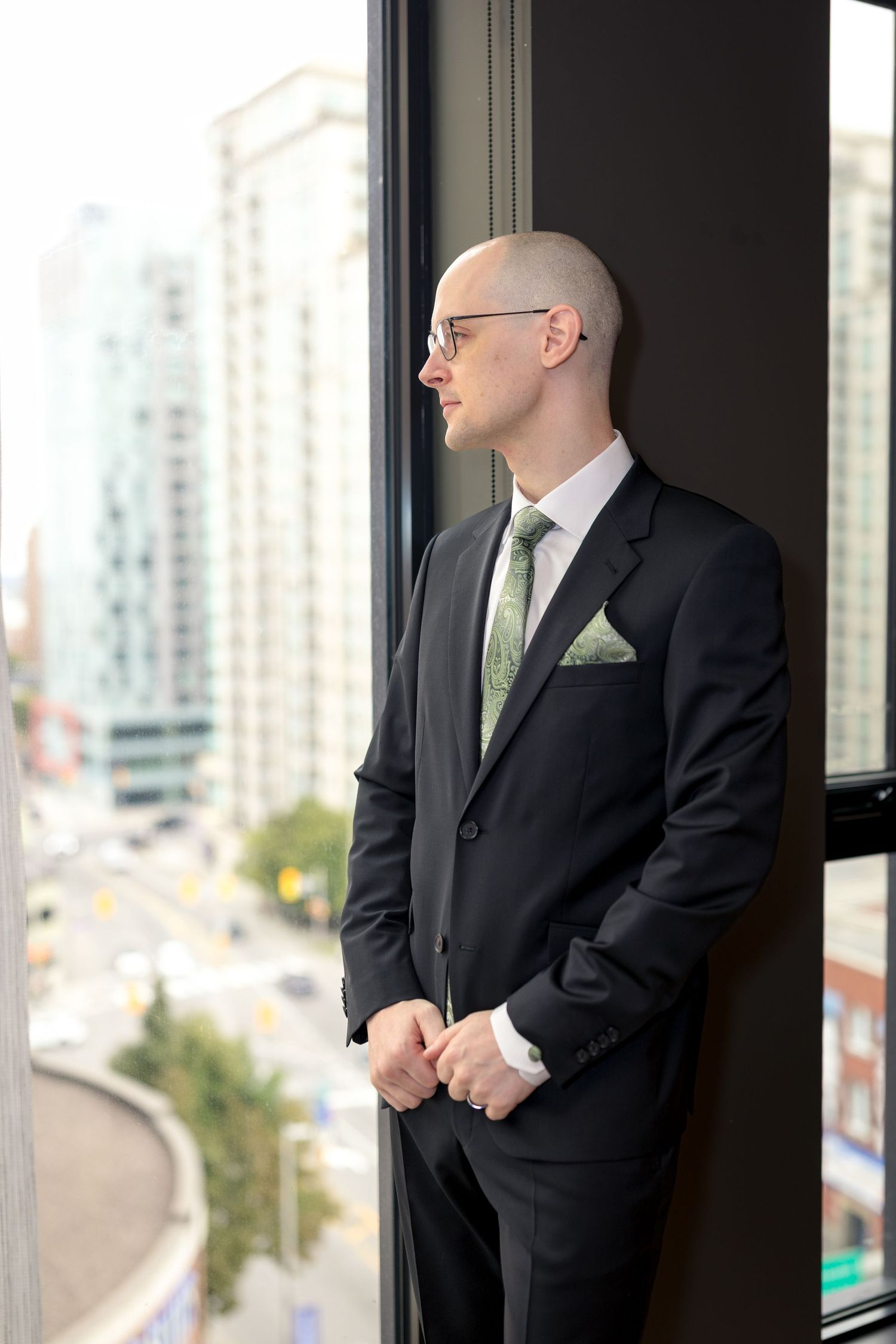The Groom calmly looks out the hotel window in anticipation of his wedding in Ottawa. Ottawa Wedding Photographer