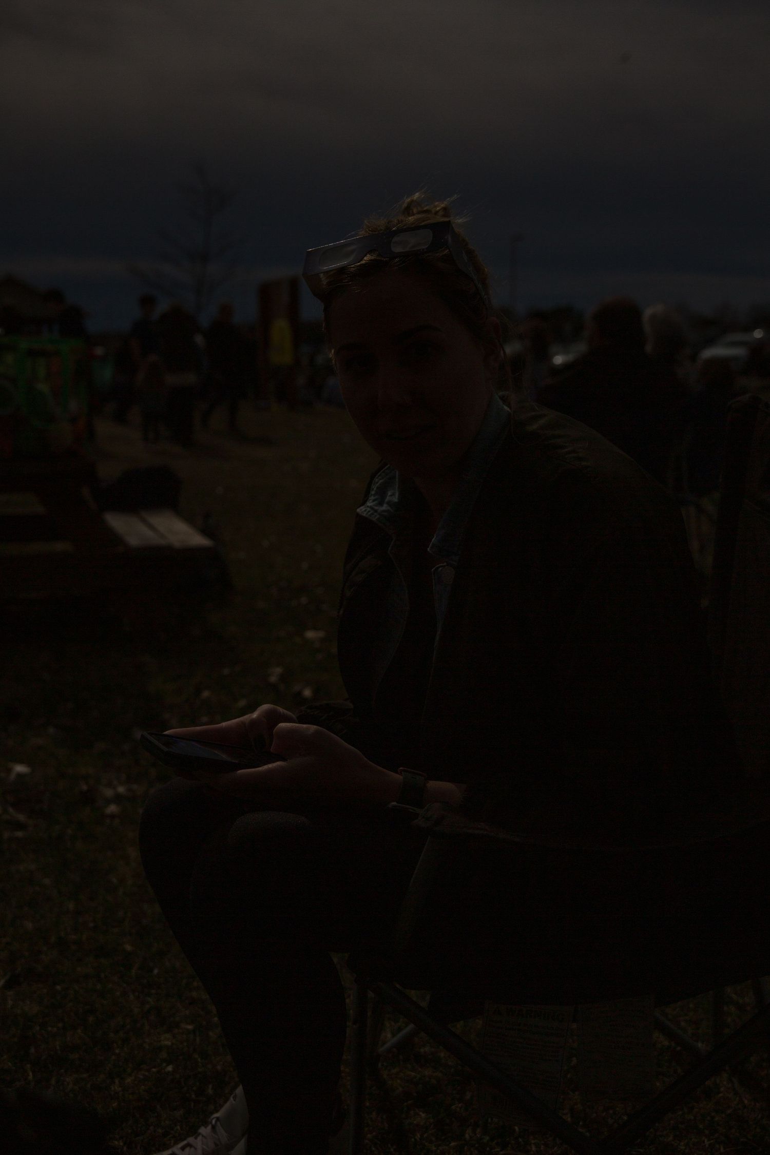 Silhouette of a person against a dark evening sky outdoors.