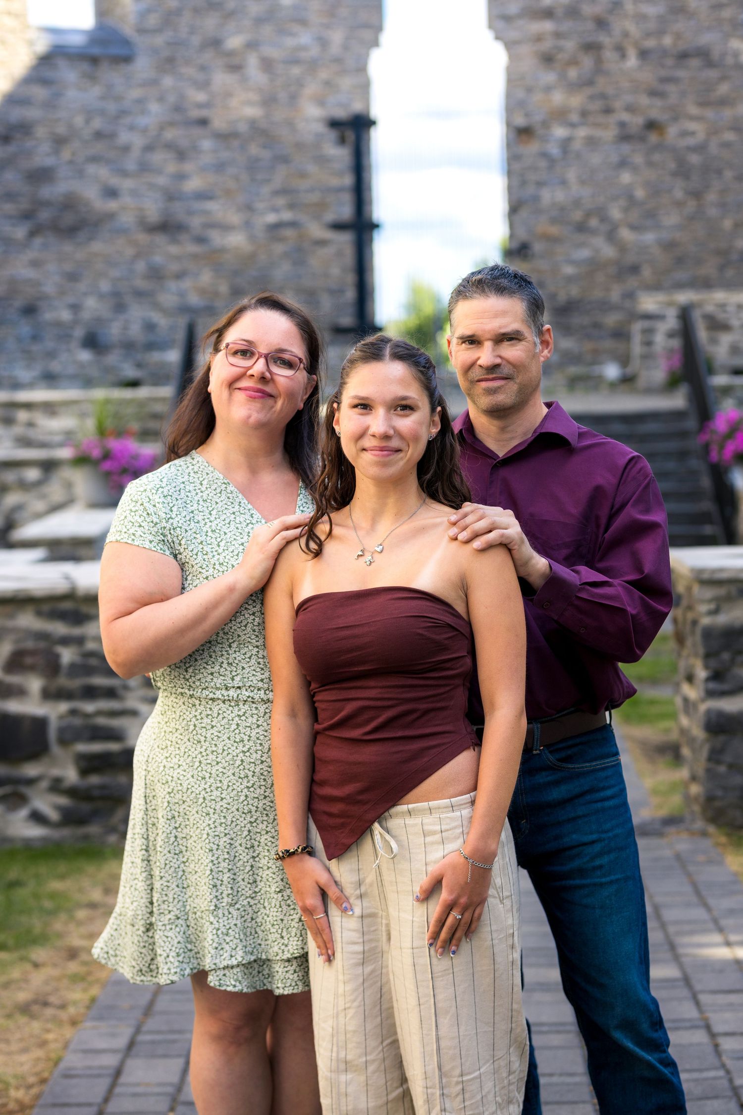 Three people pose together on stone pathway during summer day. Ottawa Family Photographer