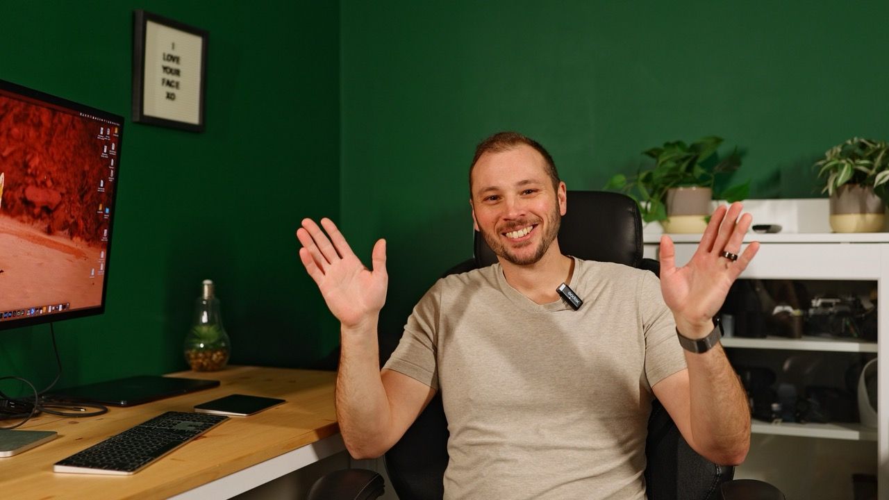 Friends socializing in dimly lit room with green walls and wooden furniture.